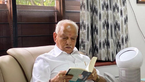 ಮನೇಲಿ ‘ಜ್ಞಾನಾರ್ಜನೆ ಎಂದೂ ಮುಗಿಯದ ಕಾಯಕ’ ಎಂಬ ಪುಸ್ತಕ ಓದುತ್ತಿದ್ದಾರೆ ಬಿಎಸ್ ವೈ