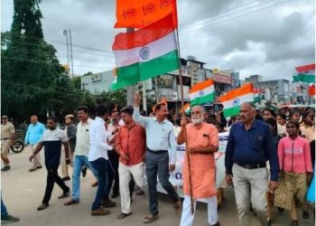 Minister Nagesh holding the saffron flag over the national flag